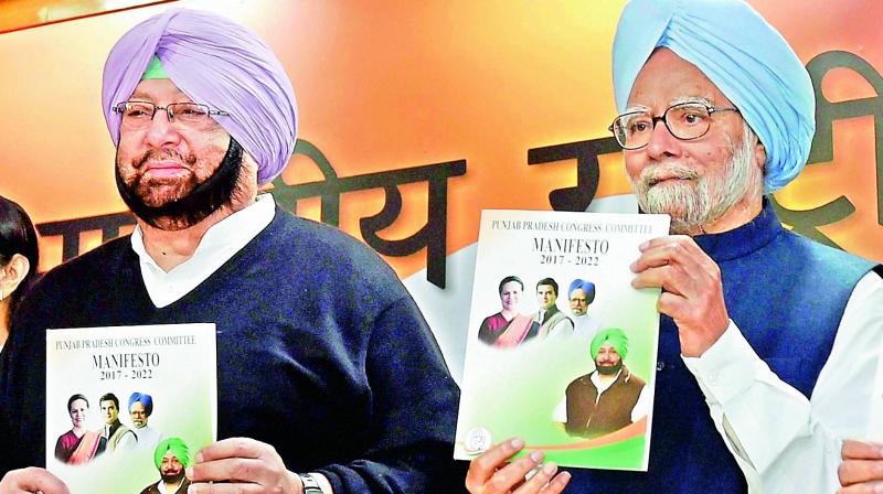 Former Prime Minister Manmohan Singh with Punjab Congress president Capt. Amarinder Singh releases the Congress manifesto in New Delhi on Monday. (Photo: PTI)