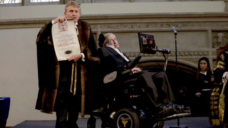 In this file photo, Britains Professor Stephen Hawking is presented with his illuminated Freedom scroll by the Chamberlain of the City of London Peter Kane as he receives the Honorary Freedom of the City of London during a ceremony at the Guildhall in the City of London. (Photo: AP)