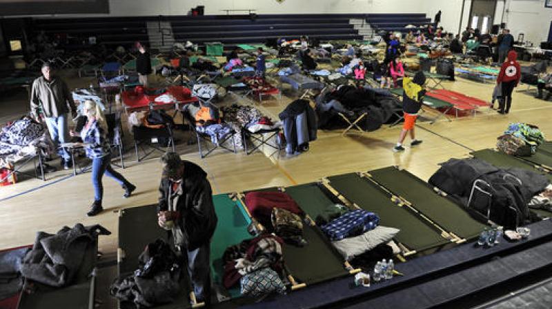 Evacuees sleep and relax at an emergency shelter set up at the Sutter High School gymnasium in Sutter, California. (Photo: AP)