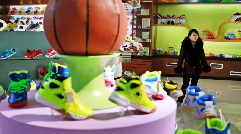 A guide stands near a basketball shoe display in a product exhibition room at the Ryuwon Shoe Factory that specialises in sports footwear, in Pyongyang. (Photo: AP)