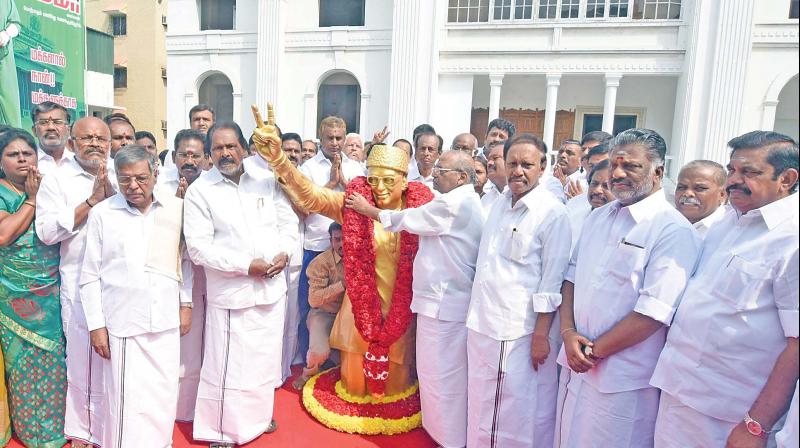 AIADMK party presidium chairman E. Madusudhanan garland the statue of the party founder M.G. Ramachandran during the partys 45th anniversary at party head office Royapettah on Monday. (Photo: DC)