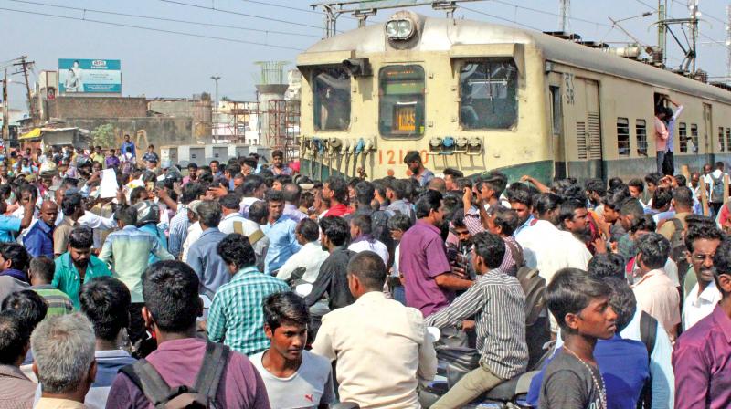 Passengers protest by halting an electric train at Kadambattur railway station on Wednesday seeking punctuality in electric trains.	(Photo:DC)