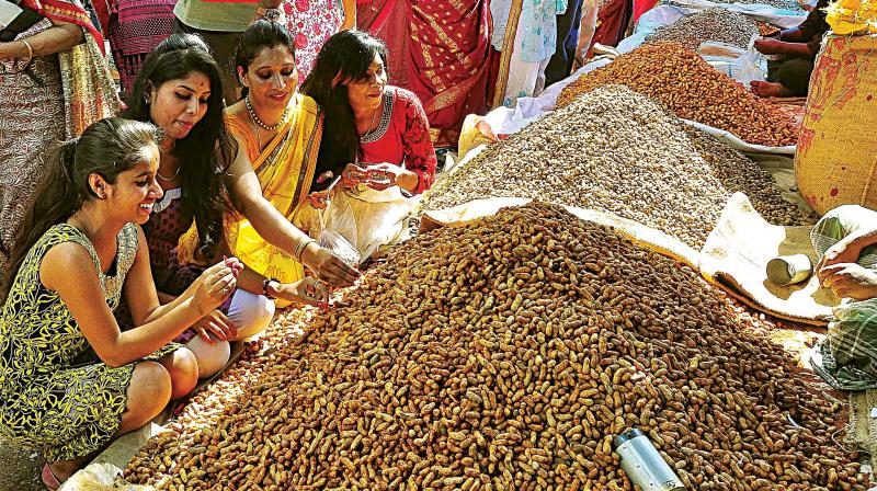 People buying groundnuts at the Kadlekai Parishe on Bull Temple Road, in Bengaluru on Monday