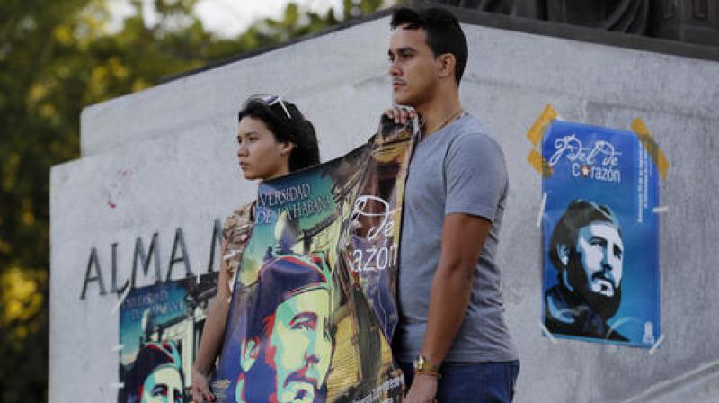Students stand at attention holding images of Fidel Castro at the university where Castro studied law as a young man, during a vigil in Havana on Sunday. (Photo: AP)