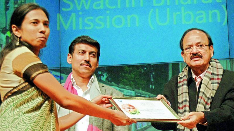 Union minister for urban development M. Venkaiah Naidu hands over the Open Defaecation-free city award under Swachh Bharat to municipal commissioner S. Nagalakshmi in Delhi on Thursday. Minister of state for information and broadcasting Colonel Rajyavardhan Singh Rathore is also seen.