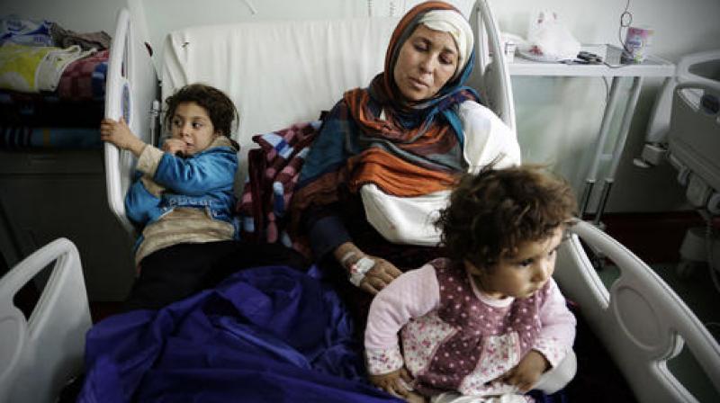 Um Yousef and her two young daughters recover in an Irbil hospital after they were badly injured in a mortar attack outside their home in Mosul. (Photo: AP)