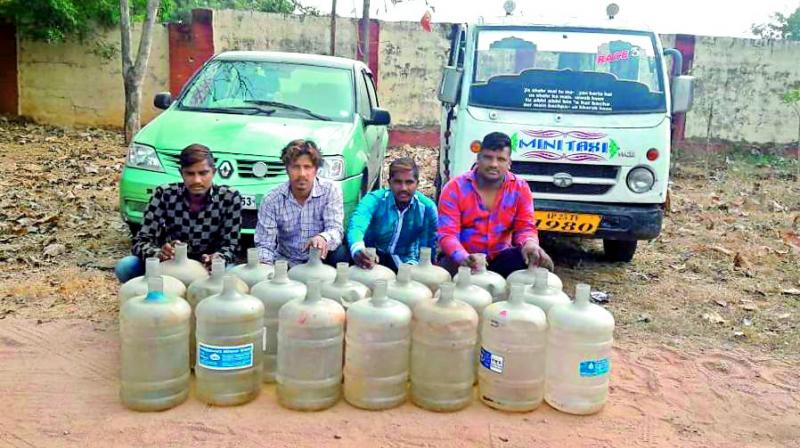 The four accused along with the car and water cans used for stealing diesel.
