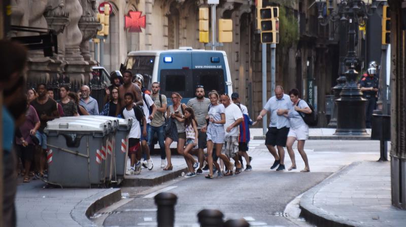 People flee from the scene after a white van jumped the sidewalk in the historic Las Ramblas district of Barcelona, Spain, crashing into a summer crowd of residents and tourists Thursday. (Photo: AP)