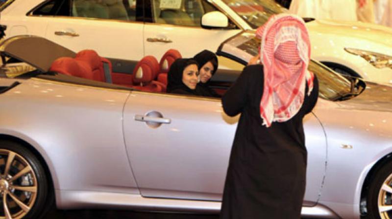 Saudi women sit in a car at a luxury motor show, yet women are still banned from driving in the kingdom. (Photo: AFP)