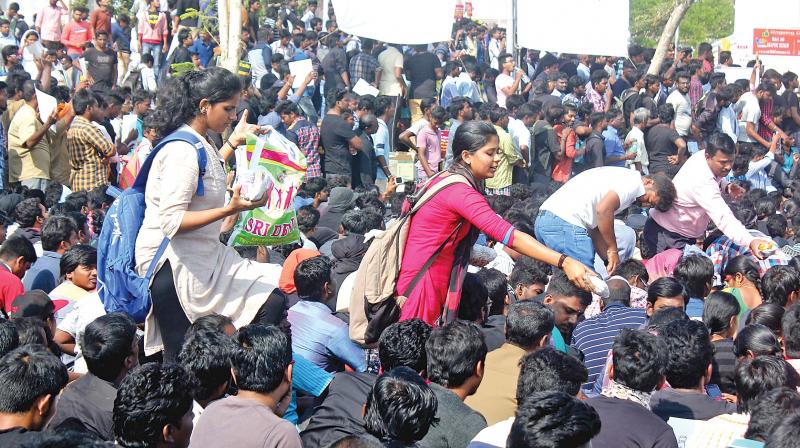 Volunteers distribute food packets to protesters in Marina beach. (Photo: DC)
