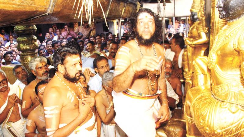New Melshanti T.M. Unnikrishnan Namboothiri (left) offers prayers before the Lord Ayyappa at Sabarimala just before taking over the charge from outgoing Melshanti S.E. Sankaran Namboothiri as the two-month long pilgrimage started on Tuesday.