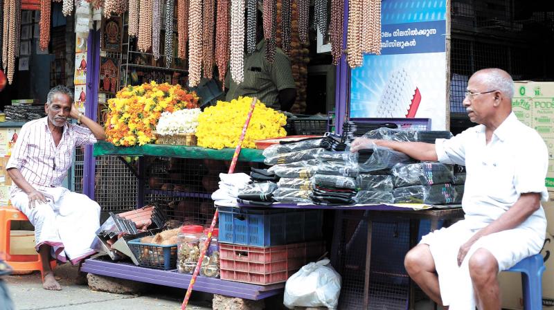 Vendors at a wayside flower store at Palayam in Kozhikode wait for business on Tuesday. (Photo: AKHIN DEV)