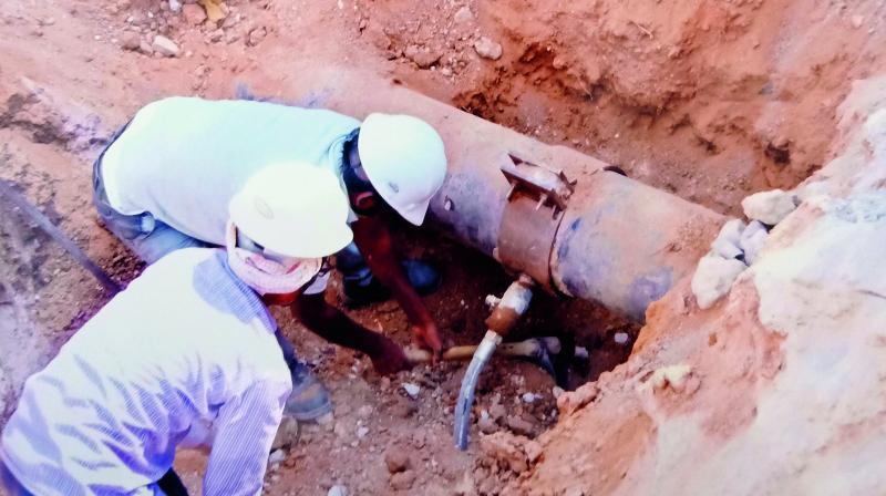 Workers inspect the hole in the pipeline made by the gang to pilfer fuel from it illegally and sell it.