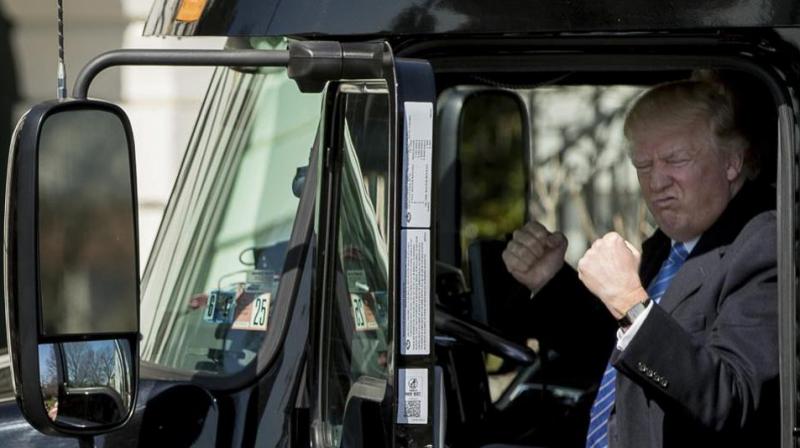 President Donald Trump gestures while sitting in an 18-wheeler truck while meeting with truckers and CEOs regarding healthcare on the South Lawn of the White House in Washington. (Photo: AP)