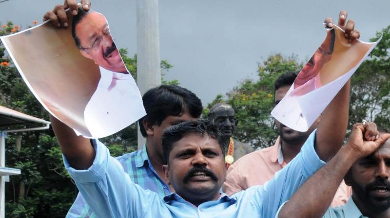 Youth Congress activists tear the poster of KPCC president M.M. Hassan and Kerala Congres leader K.M. Mani during a protest in Kochi on Friday against the Congress decision to give the Rajya sabha seat to KC(M). (Photo: ARUN CHANDRABOSE)