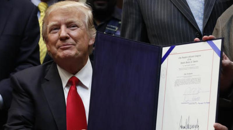 US President Donald Trump holds up H.J. Res. 38 after signing it in the Roosevelt Room of the White House. (Photo: AP)