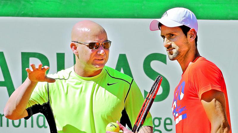 Defending champion Novak Djokovic (right) of Serbia listens to his new coach Andre Agassi of the United States during a training session for the French Open at the Roland Garros stadium in Paris on Friday. (Photo: AP)