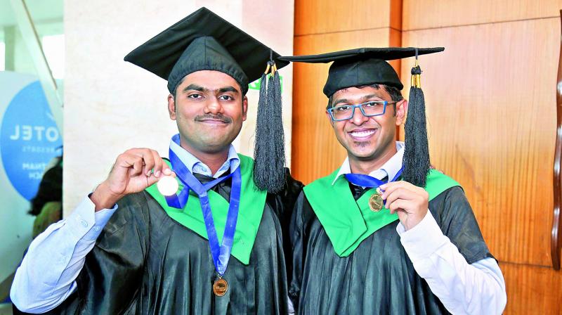 Abhishek Goel (right) receives the gold medal for first rank while V. Ganapathi Subramanian (left) receives the gold medal for second rank in academic performance at the convocation in IIM-Visakhapatnam on Friday. (Photo: DC)