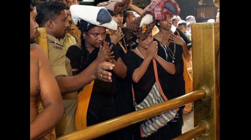 Ananya, Trupti, Renjumol and Avanthika, clad in traditional black sarees and carrying the customary \Irrumudikettu\(sacred offerings to the deity), were escorted by police from Nilackal to Pamba and during the trek to the shrine. (Photo: ANI)