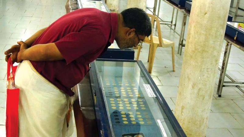 A man takes a close look at the coins exhibited at the three-day coin fest organised by Calicut Numismatic Society at Kozhikode Corporation Jubilee Hall on Saturday.