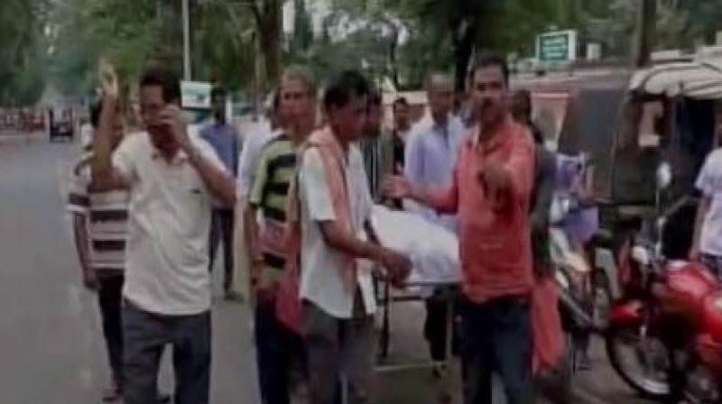 Family carry body of girl on stretcher after hospital did not provide ambulance. (Photo: ANI | Twitter)