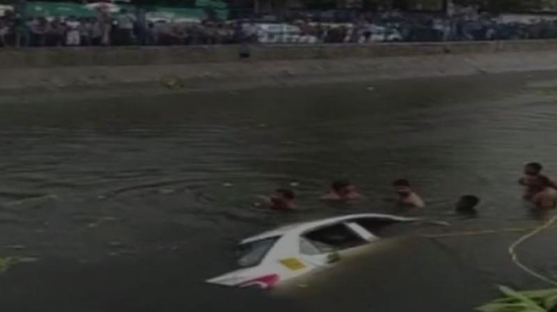 Four to five vehicles fell into Kondli canal after a garbage dump caved in at Ghazipur landfill site on Friday. (Photo: ANI | Twitter)