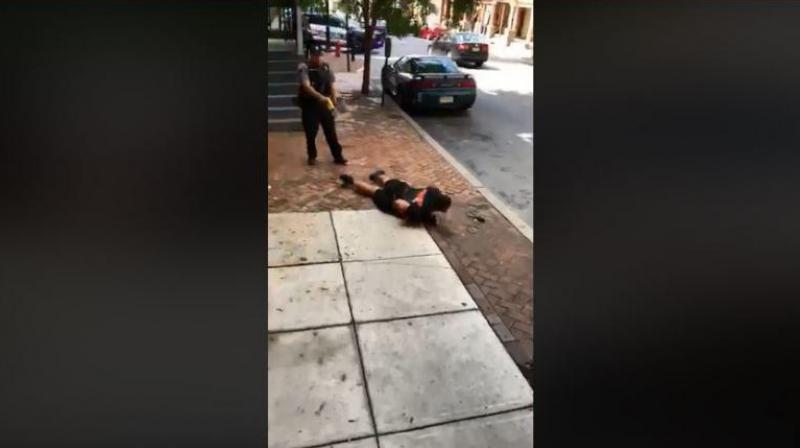 The video shows Williams sitting on a curb, being repeatedly asked to straighten his legs by Lancaster City Police Bureau Officer Philip Bernot. (Photo: Video Screengrab/Facebook)
