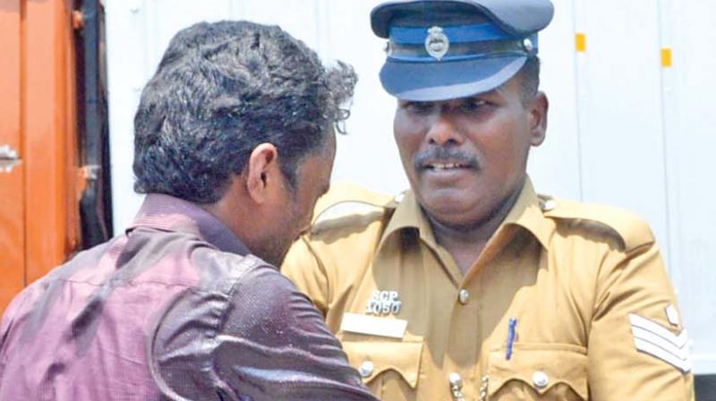 Policeman tries to stop a Dalit man from suicide bid at Salem district  collectors office on Thursday. (Photo: DC)