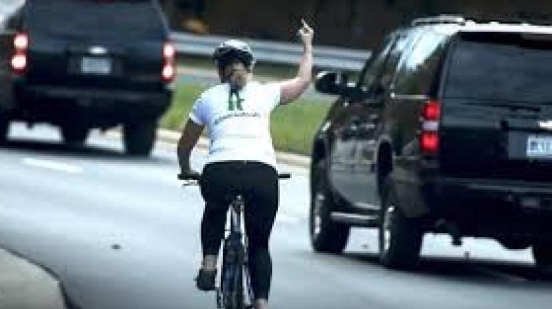 With her right hand on the handlebar, Juli Briskman raised the other to make the rude gesture. The moment was captured by AFP photographer Brendan Smialowski, and quickly went viral online. (Photo: AFP)