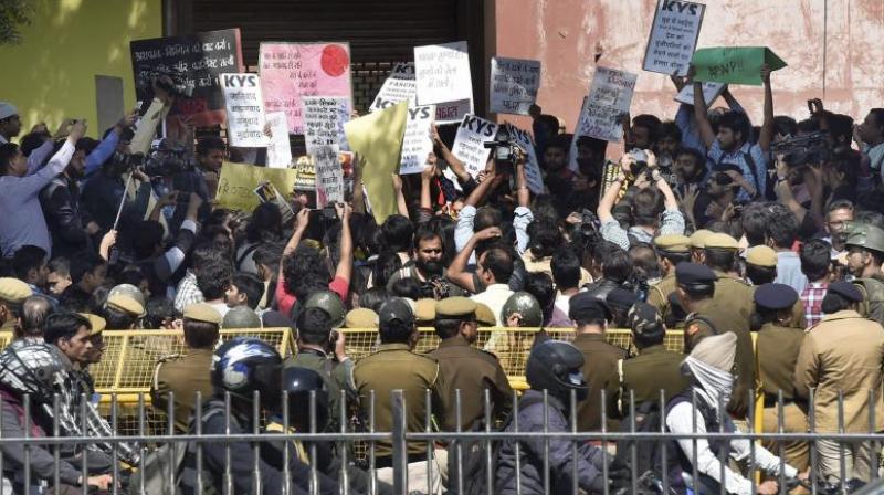 Policemen guard as All India Students Association (AISA) and Jawaharlal Nehru University students hold a protest demanding the arrest of Akhil Bharatiya Vidyarthi Parishad (ABVP) members at the police headquarters in New Delhi. (Photo: File/PTI)