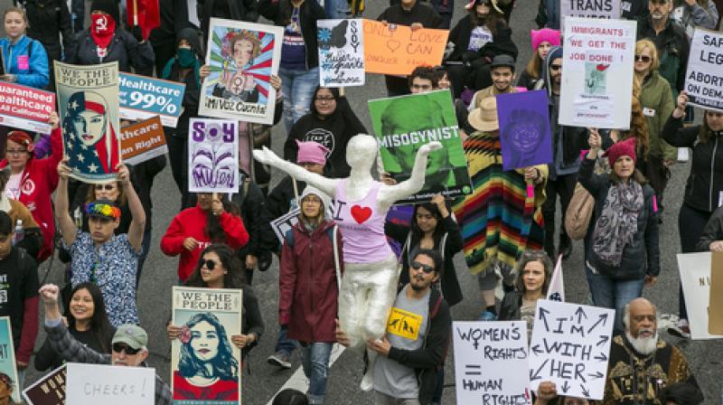 People participate in a march through downtown Los Angeles honoring International Womens Day on Sunday