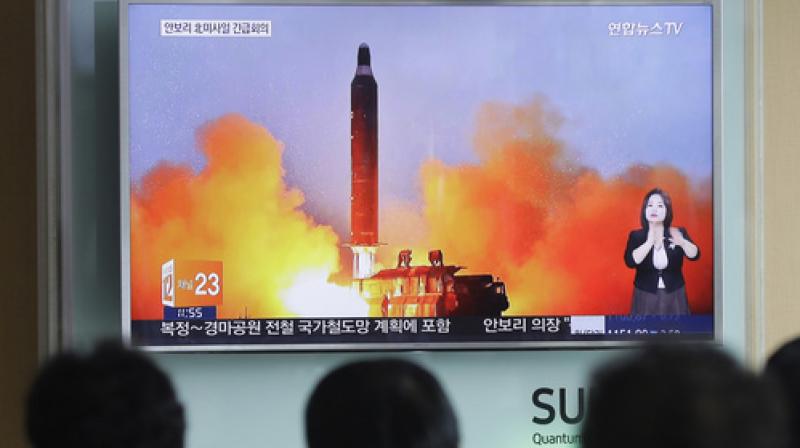 People watch a TV news channel airing an image of North Koreas ballistic missile launch published in North Koreas Rodong Sinmun newspaper (File Photo)