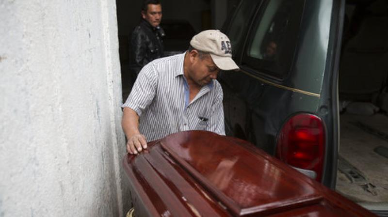 A man pushes the coffin of Keila Salguero, a victim of the Virgin of the Assumption Safe Home fire, at the morgue in Guatemala City. (Photo: AP)