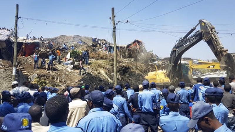 Police officers secure the perimeter at the scene of a garbage landslide, as excavators aid rescue efforts, on the outskirts of the capital Addis Ababa, Ethiopia on Sunday. (Photo: AP)