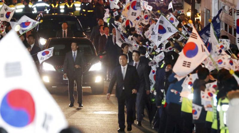 A vehicle carrying ousted South Korean President Park Geun-hye arrives through her supporters at her private home in Seoul. South Korea on Sunday, (Photo: AP)