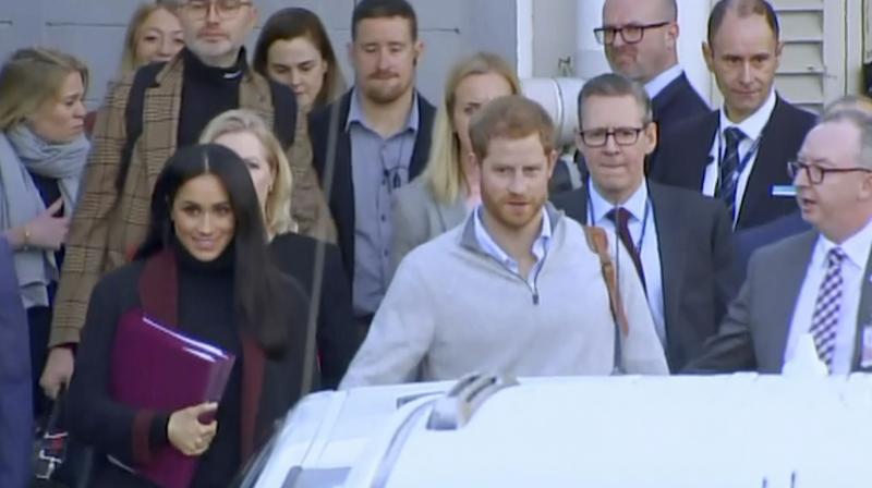 In this image made from video, Britains Prince Harry, center right, and his wife Meghan, center left, Duke and Duchess of Sussex, approach a car at an airport in Sydney, Monday, Oct. 15, 2018. (Photo: AP)
