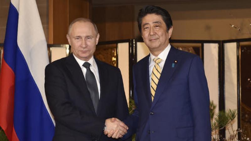 Russian President Vladimir Putin and Japanese Prime Minister Shinzo Abe pose for media during their meeting in Nagato. (Photo: AP)