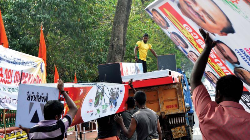 Corporation officials remove illegal hoardings along Palayam Road in Thiruvananthapuram on Monday. (Photo: DC)
