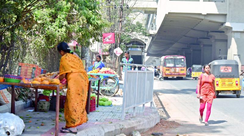 A woman sets up a vegetable stall on the footpath outside  NGRI Metro station (Photo: DC)