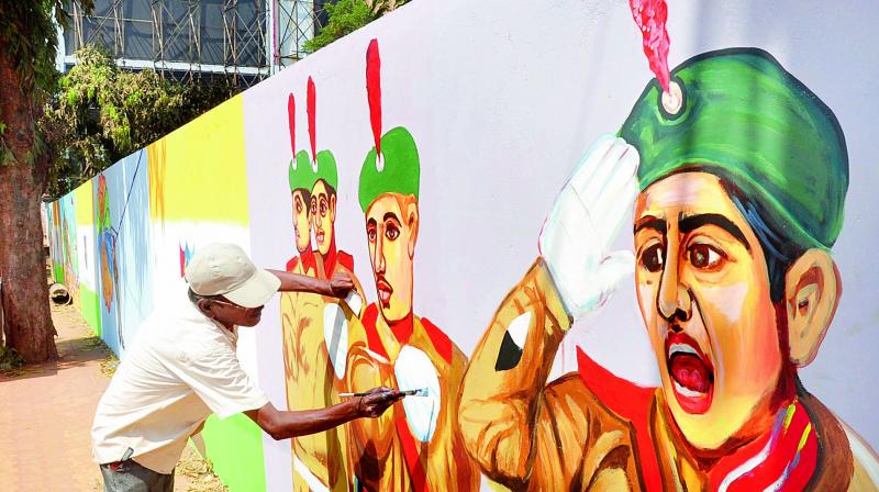 An artist paints young cadets on the walls of NCC Office near Andhra University Engineering College in Visakhapatnam on Monday. 	(Photo: DC)