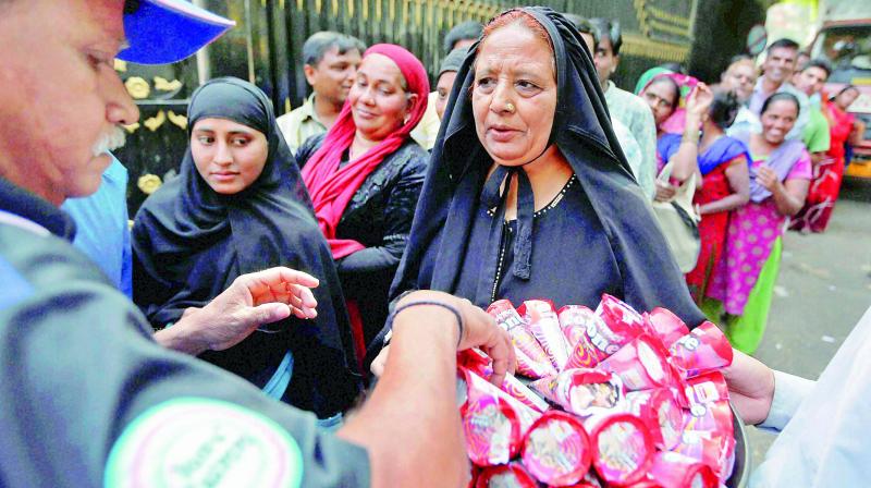 People being offered ice-creams as they wait in long queues to exchange notes in Ahmedabad on Friday. (Photo: PTI)