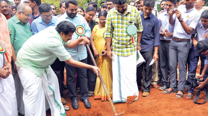 Education Minister C. Raveendranath digs the first rain pit in the premises of Medical College Campus Higher Secondary School on Monday. (Photo: Viswajith K)