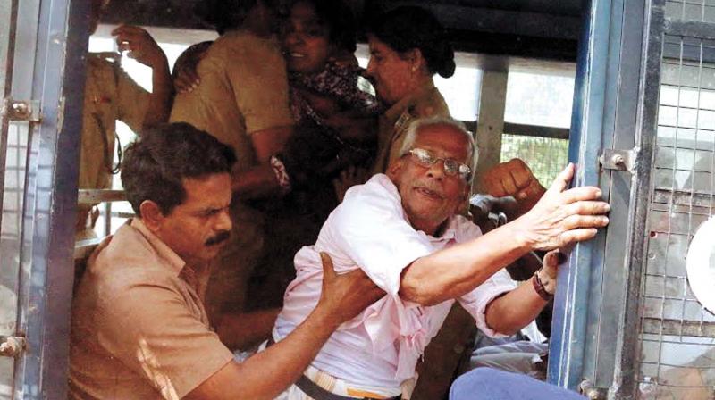 Police push in activists including M.N. Ravunni (left) into the police van when they shouted slogans in front of the mortuary at MCH, Kozhikode on Saturday.(Photo: DC)