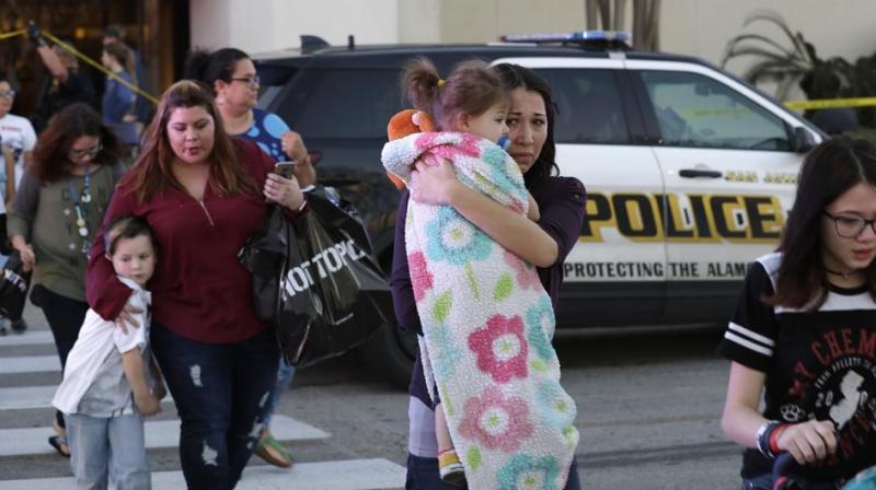 San Antonio police help shoppers exit the Rolling Oaks Mall in San Antonio, after a deadly shooting. Authorities say several were injured after a robbery at the shopping mall. (Photo: AP)