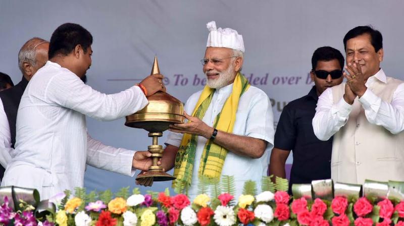 Prime Minister Narendra Modi being presented a memento at the ceremony to dedicate to nation the Dhola Sadia Bridge, across River Brahmaputra in Assam. (Photo: Twitter | PIB)