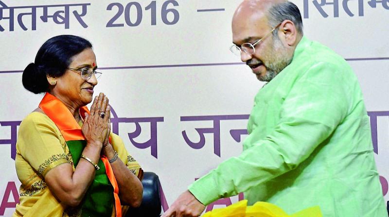 BJP President Amit Shah with former UP Congress President Rita Joshi at party headquarters in New Delhi on Thursday.(Photo: PTI)