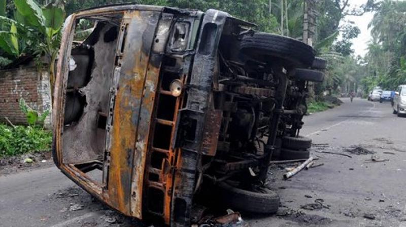 A burnt vehicle seen at a road after a communal riot at Baduria in North 24 Pargana district of West Bengal on Wednesday. (Photo: PTI)
