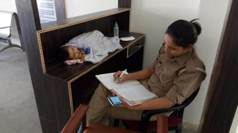 Like any other day, Archana Jayant was present along with her daughter, Anika, in police station in Uttar Pradeshs Jhansi district, but was clicked by someone and her picture went viral on social media three days ago. (Photo: Twitter | @upcoprahul)