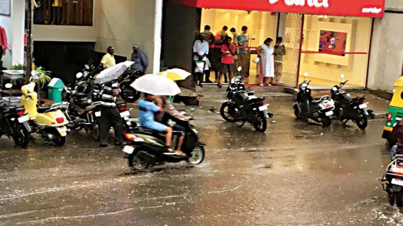 Unexpected rain hit motorist and pedestrians at BTM Layout in Bengaluru on Saturday KPN