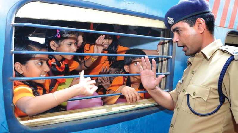 Mukesh Chand Meena, a Railway Protection Force official, gives the students of St Stephens LP School, Parambencherry, Muvattupuzha, the safety tips while travelling in train at Kochi on Friday (Photo: DC)